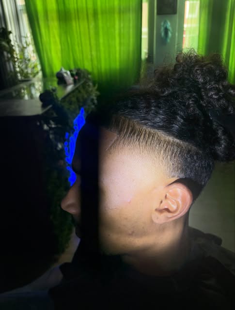 Taper fade met een geleidelijke overgang en krullen bovenop